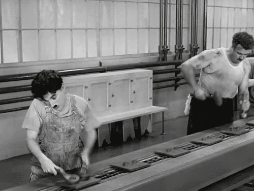 Gif de Charlie Chaplin na cena em que está agitado apertando parafusos em uma esteira de fábrica.
