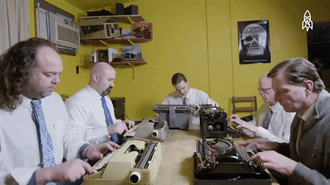Imagem animada de 5 homens engravatados sentados à mesa, datilografando em máquinas de escrever antigas.