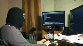 Gif de um rapaz usando uma balaclava e chacoalhando enquanto finge mexer num código no computador.